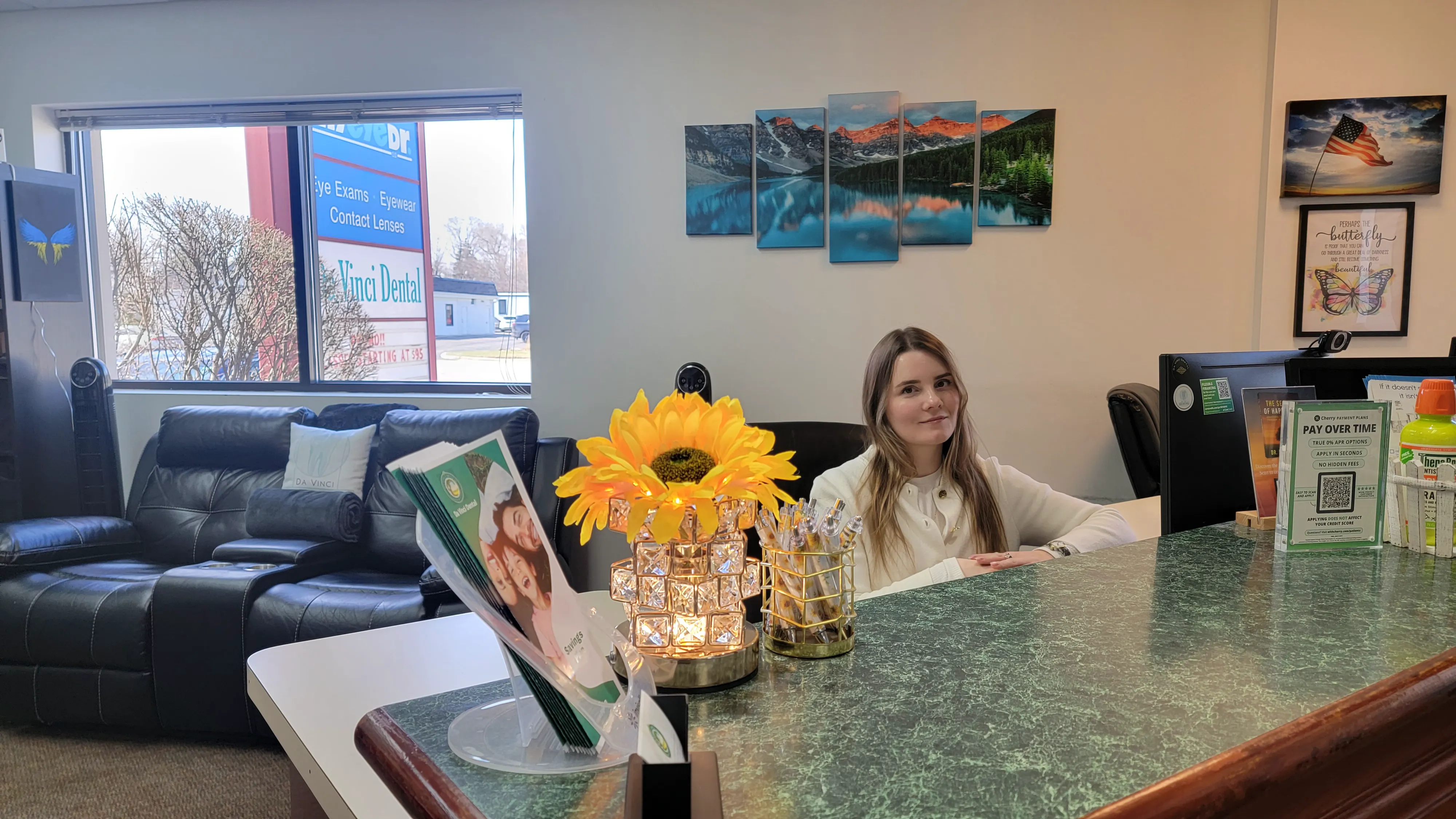 Friendly receptionist at Da Vinci Dental with sunflowers and mountain art